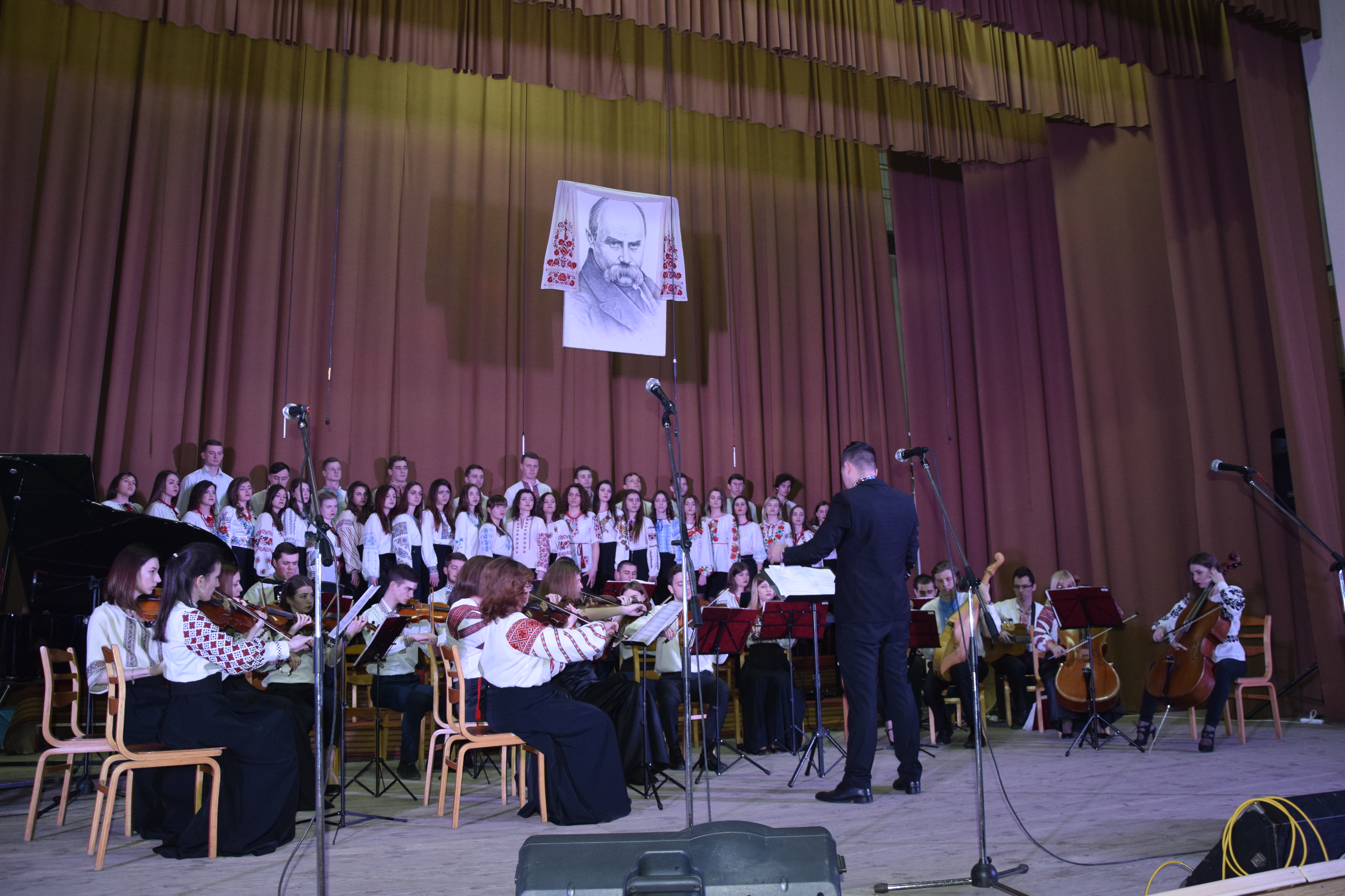 Звучить «Заповіт» (слова Тараса Шевченка, музика Гната Хоткевича) у виконанні хорової капели та оркестру факультету мистецтв. Диригує - Назар Лещук